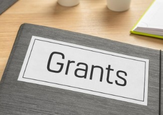 A folder that says grants on a desk.